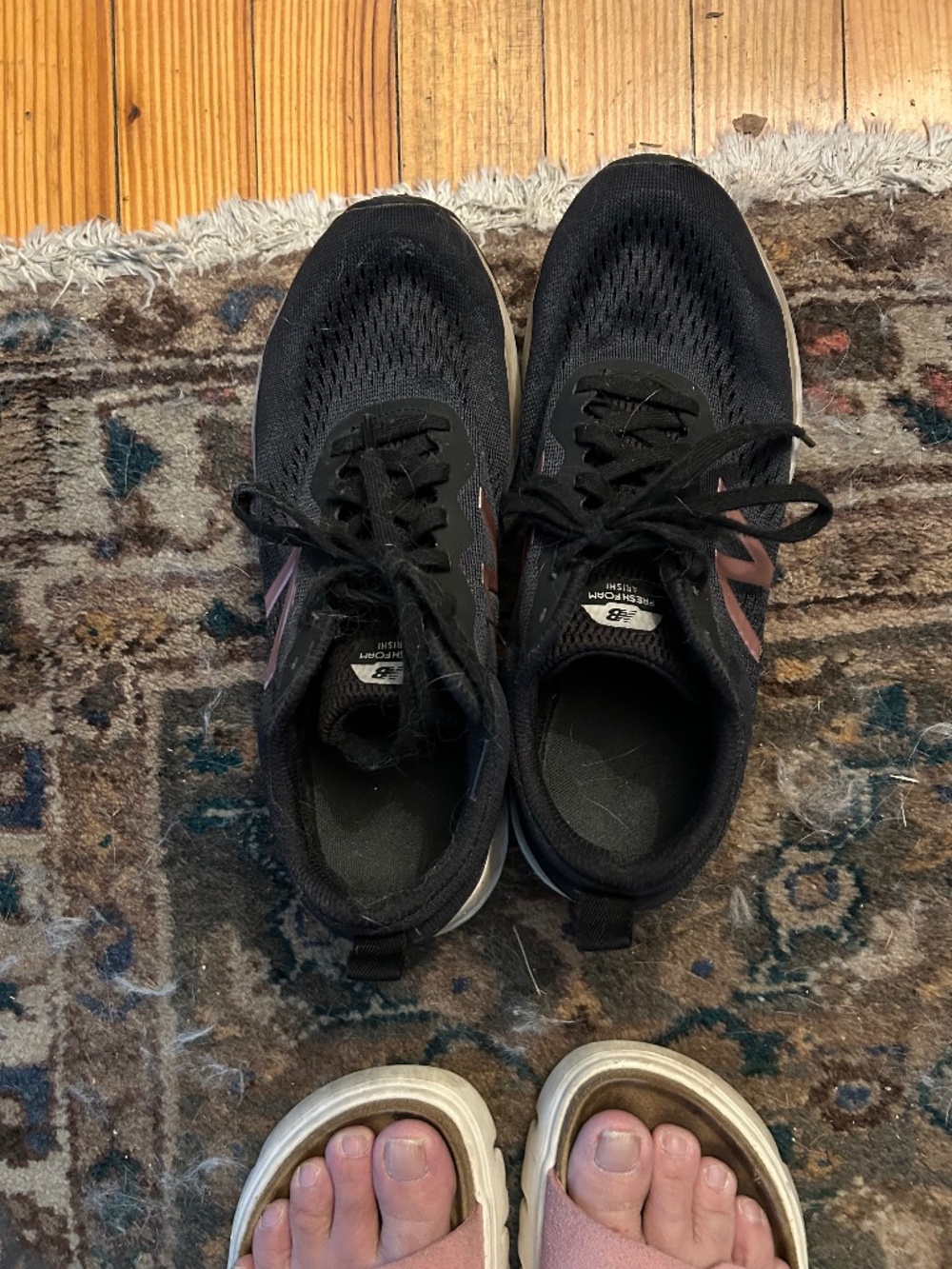 Well worn New Balance black with rose gold "N" running shoes in women's size 9.5